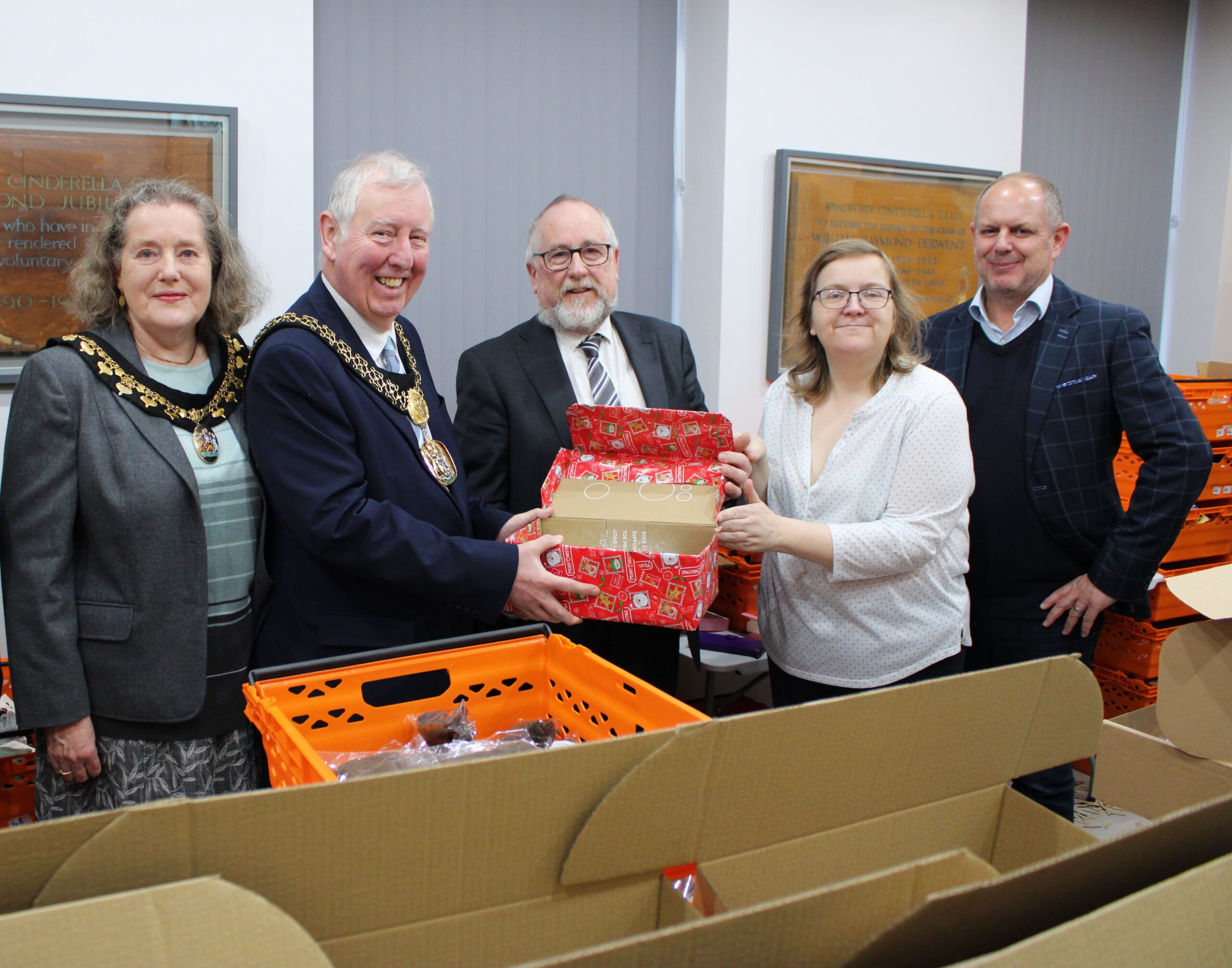Group photo of The Lady and Lord Mayor, Terry Pearson and Rachel Thompson from the Cinderella Club and JM Glendinning Insurance Brokers Guiseley managing director, Ian Vinall, holding a shoe box.